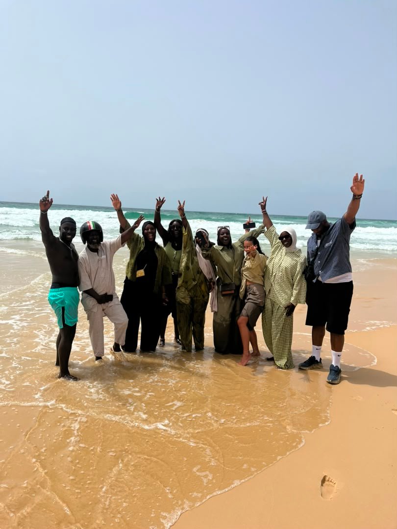 Groupe levant les bras sur la plage