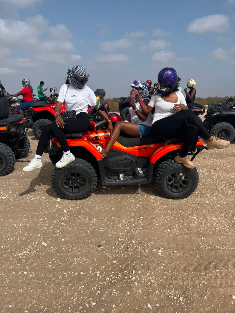 Voyageuses échangeant autour d’un quad rouge